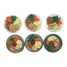 four plates filled with different types of food on top of each other in front of a white background