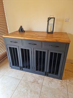 a wooden table with metal doors on it and a candle sitting on top of it