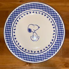 a blue and white plate with a drawing of a bear on the rim, sitting on a wooden floor