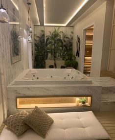 a bathroom with a large jacuzzi tub next to a white bench and potted plant