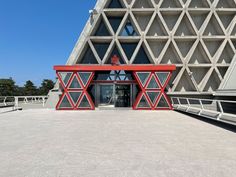 the entrance to an architectural building with red and white geometric designs on it's sides