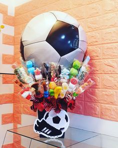 a large soccer ball sitting on top of a table next to a vase filled with candy