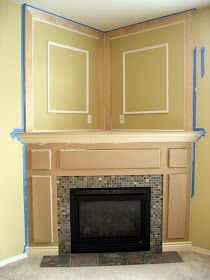 an empty room with a fireplace in the middle and blue tape on the wall around it