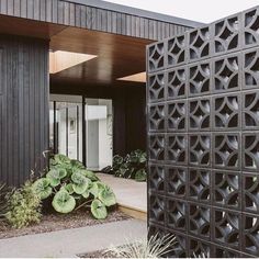 the entrance to a modern home with an intricate design on the outside wall and door