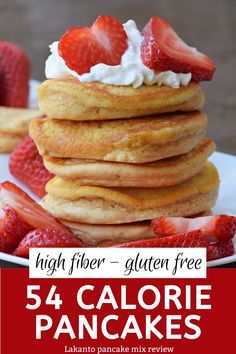 pancakes stacked on top of each other with whipped cream and strawberries in the background