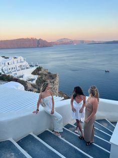 three women standing on the edge of a building