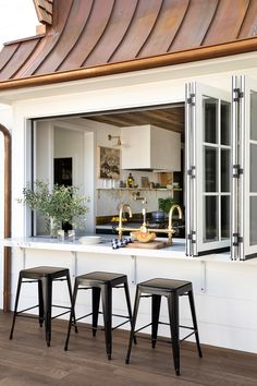 three stools sit in front of an open window on the outside of a house