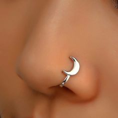 a close up view of a nose with a crescent ring on it's side