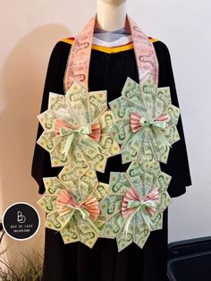 a graduation gown with money origami flowers on the front, and a black dress underneath