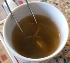 there is a cup of tea with two spoons in it