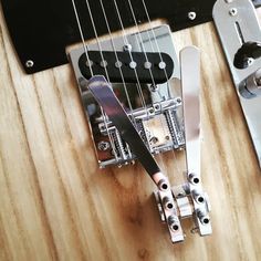 an electric guitar is being worked on by someone with a pair of pliers attached to it