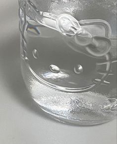 an image of a glass with hello kitty on it's face in the water