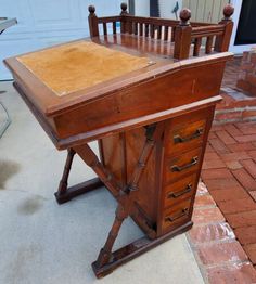 an old wooden desk with drawers on the top and bottom, in front of a garage door