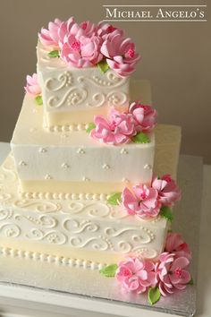 a three tiered cake with pink flowers on top