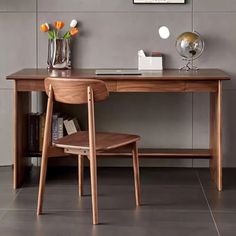 a wooden desk with two chairs next to it and a vase filled with tulips