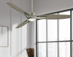 a ceiling fan in a room with large windows