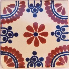 a red, white and blue flowered design on a square plate