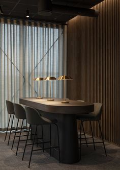 a table with four chairs and a lamp on it in front of a curtained window