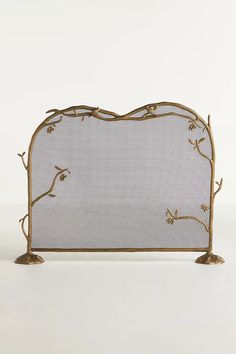 a white and gold headboard with branches on the top, against a white background