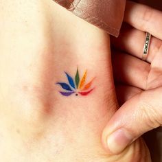 a woman's foot with a colorful flower tattoo on her left side ribcage