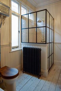 a bathroom with a radiator, toilet and window