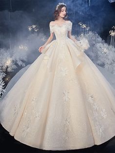 a woman in a ball gown standing on a stage with snowflakes behind her