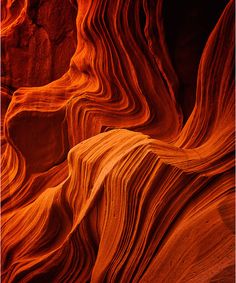 an orange rock formation in the desert with wavy lines on it's face and bottom