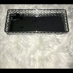 a black and silver tray sitting on top of a white rug