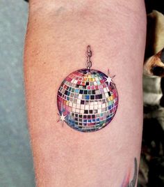 a colorful disco ball tattoo on the arm