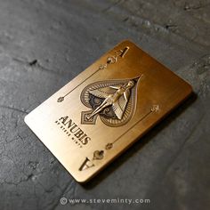 a gold playing card with an image of a bird on the front and numbers on the back