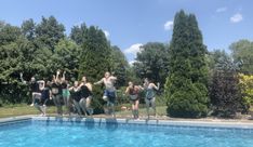 a group of people jumping into a swimming pool