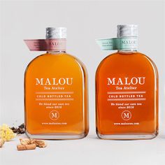 two bottles of malou tea sitting next to each other