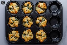 muffins with spinach and cheese in a baking pan on a counter top