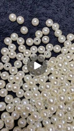 white pearls are scattered on a black surface