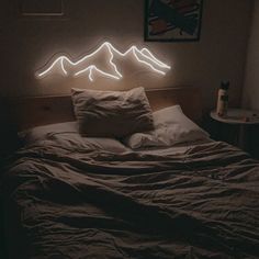 a bed that has some lights on the side of it and mountains in the background