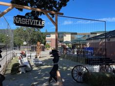 people are walking around in front of the nashville sign