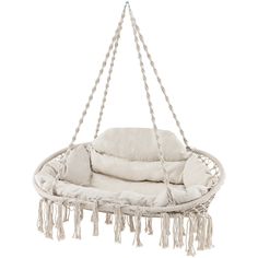 a white hanging chair with pillows and tassels on the bottom, in front of a white background