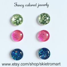 four different colored glass cabochles on a white background with the words fancy colored jewelry