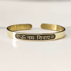 "Om Namah Shivay Sacred Bracelets, Mantra Bracelet \"Aum Namah Shivaya \"Open Face Cuff Bangle, Sacred Bracelets for Spiritual Bliss, Yoga Gifts You can buy gifts for your loved ones with a personalized bangle.  It will be a unique experience for your Loved one. All of the products are made of sterling silver & brass. We can also make 14k gold upon request. ►HOW TO ORDER 1- Please select your preferred bracelet size from the variations. 2- Please select your preferred metal from the variations. 3- Please write your preferred name you want at the ''Add your personalization'' box for inside marking at checkout. (To avoid mistakes, please write as in the example shown below.) ►PRODUCT DETAILS The material is Solid Sterling Silver, 14k solid gold & Brass. This beautiful bangle comes with a spe Symbolic Adjustable Bracelets For Festivals, Adjustable Symbolic Bracelets For Festivals, Adjustable Symbolic Bracelets For Festival, Adjustable Spiritual Bracelets For Festivals, Adjustable Spiritual Bracelet Wristband, Adjustable Symbolic Hand Stamped Jewelry, Adjustable Spiritual Bangle Bracelet, Adjustable Hand Stamped Symbolic Jewelry, Adjustable Gold Bangle With Stamped Details