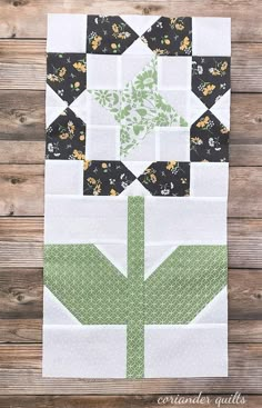 the block is made up of blocks with green and white flowers on them, along with black and white quilts