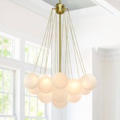 a chandelier hanging from the ceiling in a room with white walls and windows