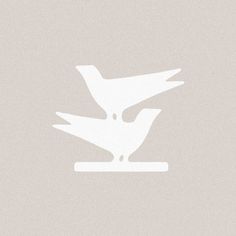 two birds sitting on top of each other in front of a light gray background with white lettering