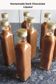 six bottles filled with liquid sitting on top of a counter next to each other and the caption reads homemade dark chocolate liqueur