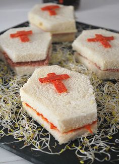 four small sandwiches with red crosses on them