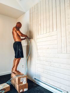 a man is using a power washer on the wall