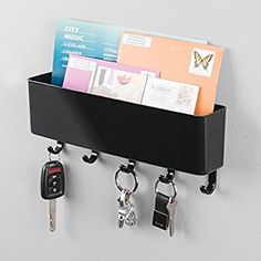 a black shelf with keys and key holders attached to it