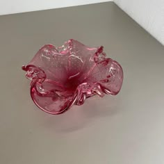 a pink glass bowl sitting on top of a table