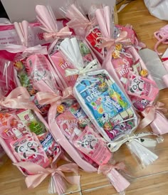 many pink items are wrapped in plastic and tied with bows on the floor next to each other