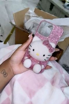 a person holding a hello kitty phone case in their hand