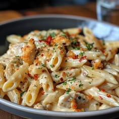 a bowl filled with pasta and sauce on top of a wooden table